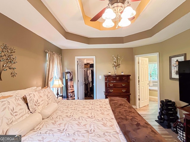 6830 Peeksville Rd, Mcdonough, GA 30252 - bedroom featuring a raised ceiling, a spacious closet, ensuite bath, a closet, and wood finished floors