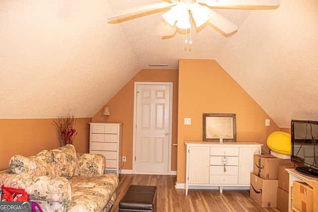 6830 Peeksville Rd, Mcdonough, GA 30252 - living area with wood finished floors, vaulted ceiling, a ceiling fan, and a textured ceiling