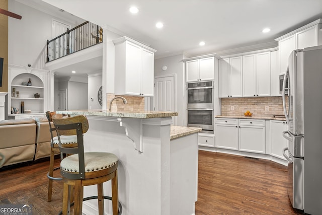 702 Crescent Cir, Canton, GA 30115 - kitchen featuring stainless steel appliances, crown molding, a peninsula, recessed lighting, and dark wood finished floors