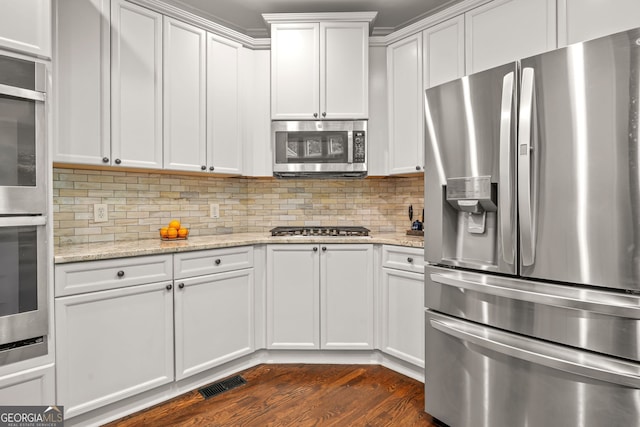 702 Crescent Cir, Canton, GA 30115 - kitchen featuring stainless steel appliances, tasteful backsplash, white cabinets, dark wood-type flooring, and light stone countertops
