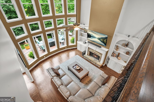 702 Crescent Cir, Canton, GA 30115 - living area with a high ceiling, ceiling fan, a stone fireplace, wood finished floors, and built in features