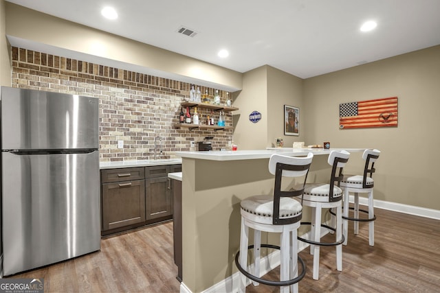 702 Crescent Cir, Canton, GA 30115 - indoor wet bar with freestanding refrigerator, light wood finished floors, decorative backsplash, baseboards, and recessed lighting