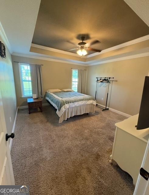4961 Bentwood Ct, Valdosta, GA 31601 - carpeted bedroom with a tray ceiling, ornamental molding, baseboards, and ceiling fan