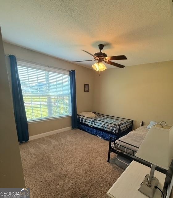 4961 Bentwood Ct, Valdosta, GA 31601 - bedroom with carpet flooring, baseboards, a textured ceiling, and a ceiling fan
