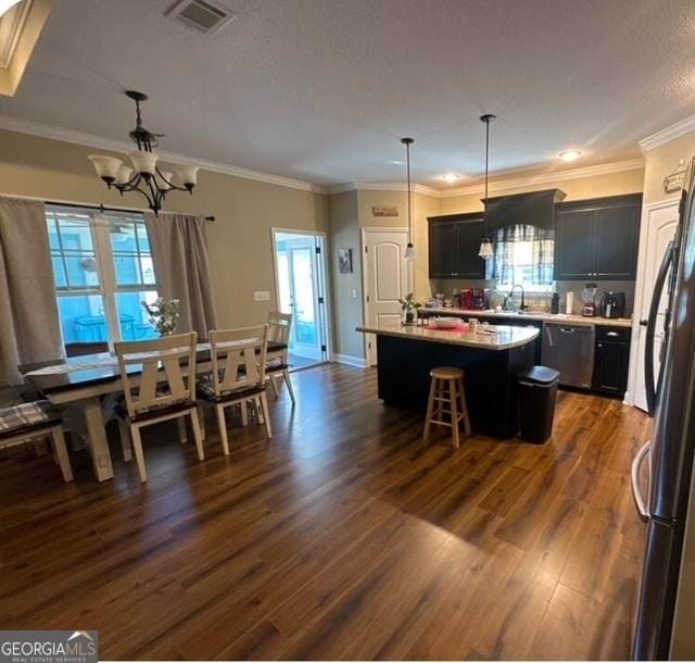 4961 Bentwood Ct, Valdosta, GA 31601 - kitchen featuring a chandelier, appliances with stainless steel finishes, a center island, dark wood-style flooring, and light countertops