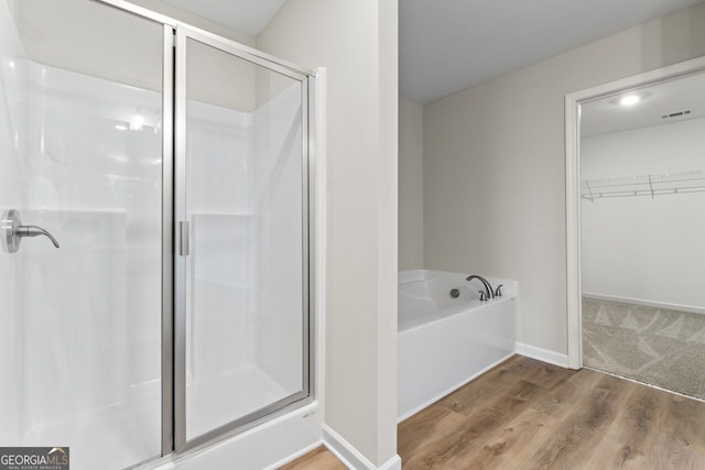 2811 Fareed, Douglasville, GA 30135 - bathroom featuring a shower stall, a walk in closet, a bath, and wood finished floors