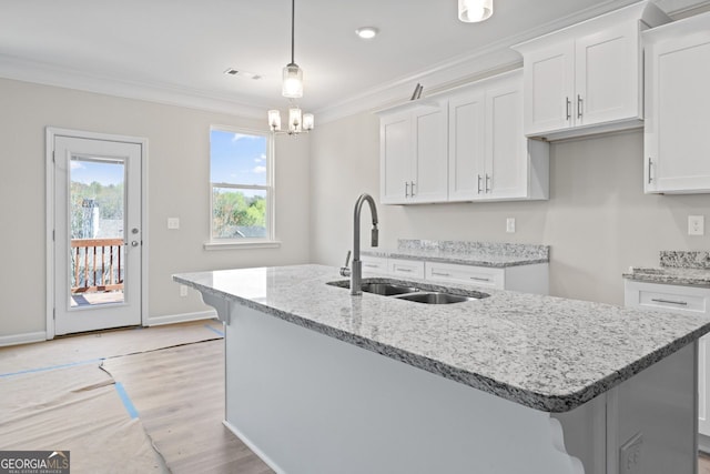 2811 Fareed, Douglasville, GA 30135 - kitchen featuring a sink, crown molding, white cabinetry, an island with sink, and light stone counters