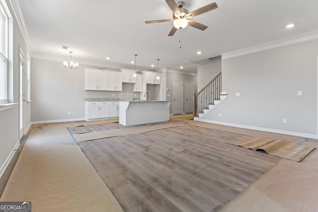 2811 Fareed, Douglasville, GA 30135 - unfurnished living room featuring ornamental molding, baseboards, recessed lighting, a ceiling fan, and a chandelier