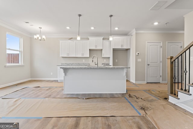 2811 Fareed, Douglasville, GA 30135 - kitchen featuring ornamental molding, baseboards, white cabinets, a kitchen island with sink, and a chandelier