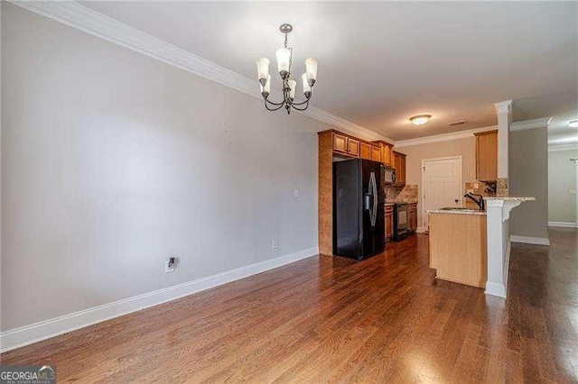 2500 Morgan Chase Dr, Buford, GA 30519 - kitchen with black appliances, crown molding, a chandelier, baseboards, and dark wood-style flooring