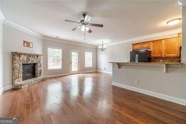 2500 Morgan Chase Dr, Buford, GA 30519 - unfurnished living room featuring a chandelier, a ceiling fan, a fireplace, dark wood-type flooring, and crown molding