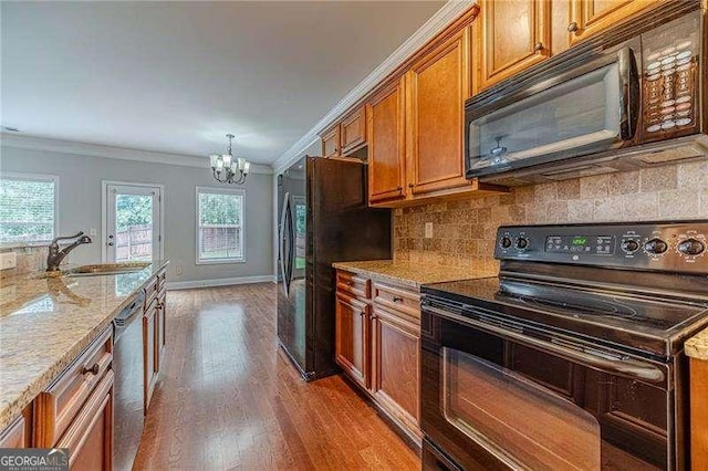 2500 Morgan Chase Dr, Buford, GA 30519 - kitchen with black appliances, a sink, a chandelier, crown molding, and brown cabinets