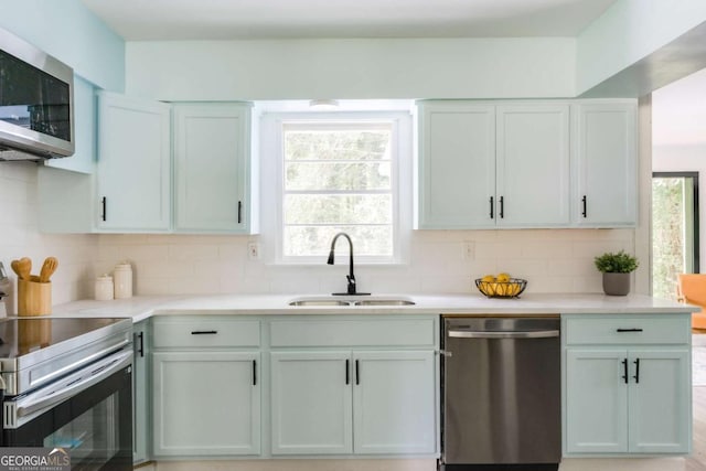 2343 Dawn Dr, Decatur, GA 30032 - kitchen with stainless steel appliances, a sink, tasteful backsplash, and light countertops