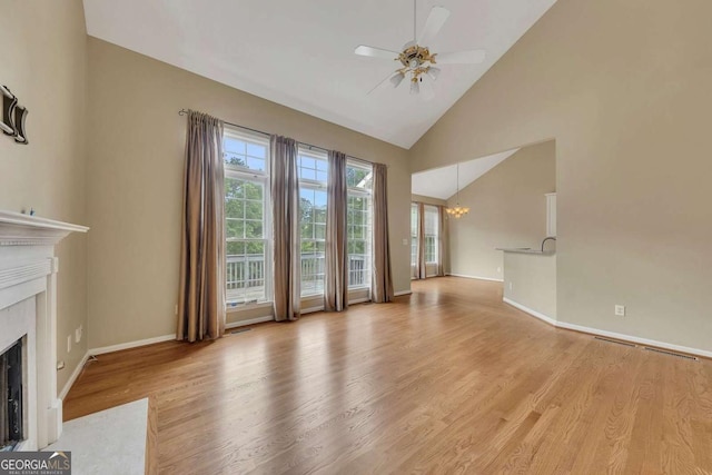 4815 Rapids Cir NW, Acworth, GA 30102 - unfurnished living room featuring a high end fireplace, a chandelier, light wood-style floors, ceiling fan, and high vaulted ceiling