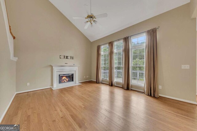 4815 Rapids Cir NW, Acworth, GA 30102 - unfurnished living room featuring a fireplace with flush hearth, light wood-style floors, high vaulted ceiling, and ceiling fan