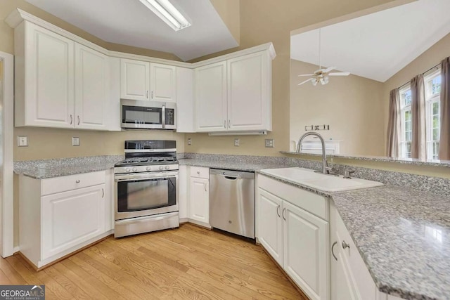4815 Rapids Cir NW, Acworth, GA 30102 - kitchen with appliances with stainless steel finishes, light wood-style floors, ceiling fan, white cabinetry, and vaulted ceiling