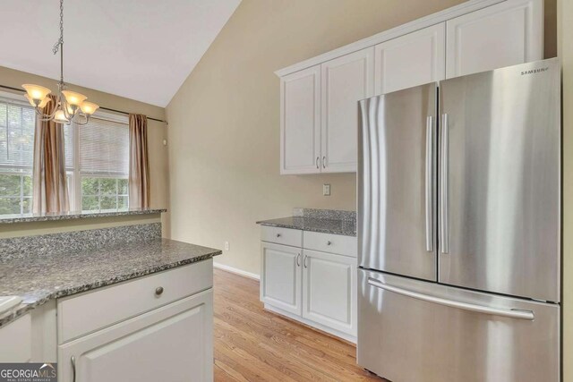 4815 Rapids Cir NW, Acworth, GA 30102 - kitchen with freestanding refrigerator, light wood-style flooring, healthy amount of natural light, a chandelier, and lofted ceiling