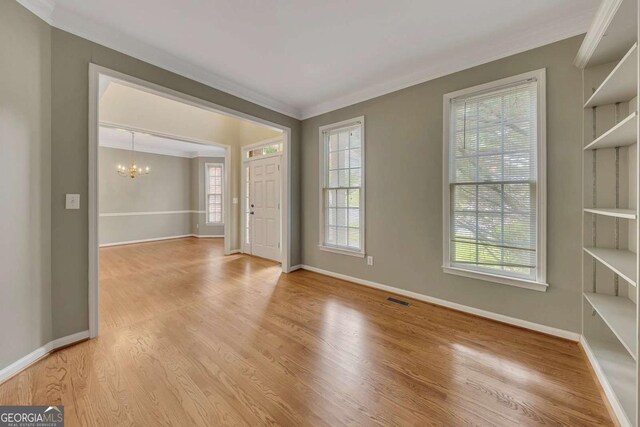 4815 Rapids Cir NW, Acworth, GA 30102 - spare room featuring a chandelier, ornamental molding, and light wood-style floors