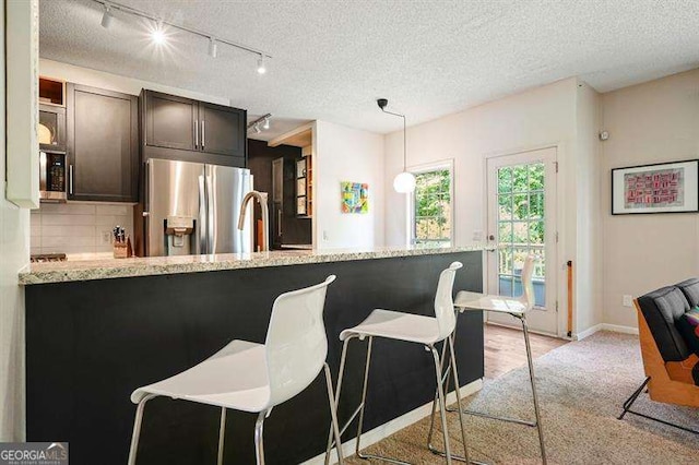 2004 Spicers Ln, Woodstock, GA 30189 - kitchen with stainless steel fridge with ice dispenser, rail lighting, decorative backsplash, dark brown cabinetry, and a textured ceiling