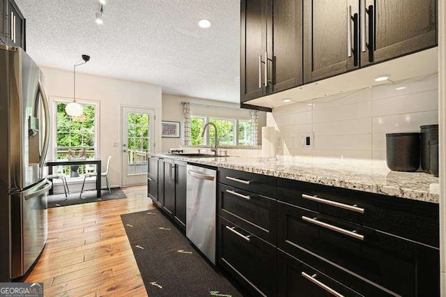 2004 Spicers Ln, Woodstock, GA 30189 - kitchen with stainless steel appliances, a sink, backsplash, light wood-style flooring, and light stone countertops