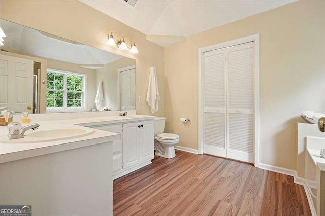 2004 Spicers Ln, Woodstock, GA 30189 - full bath with double vanity, wood finished floors, toilet, baseboards, and a closet