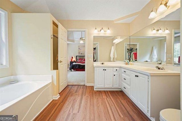 2004 Spicers Ln, Woodstock, GA 30189 - bathroom featuring ensuite bath, wood finished floors, double vanity, a garden tub, and ceiling fan