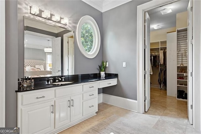 1070 Standard Dr NE, Brookhaven, GA 30319 - bathroom with vanity, tile patterned floors, crown molding, and a walk in closet