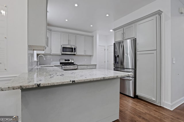 11280 Brookhollow Trl, Alpharetta, GA 30022 - kitchen featuring stainless steel appliances, gray cabinets, a peninsula, light stone countertops, and dark wood-type flooring