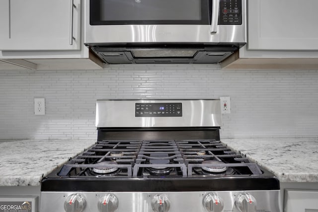 11280 Brookhollow Trl, Alpharetta, GA 30022 - kitchen view of stainless steel appliances, decorative backsplash, white cabinetry, and light stone countertops