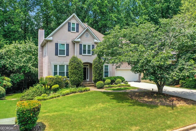 11280 Brookhollow Trl, Alpharetta, GA 30022 - traditional-style home featuring stucco siding, concrete driveway, a chimney, a front lawn, and a garage