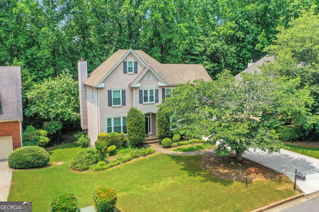 11280 Brookhollow Trl, Alpharetta, GA 30022 - colonial house featuring stucco siding, a front lawn, a chimney, and concrete driveway