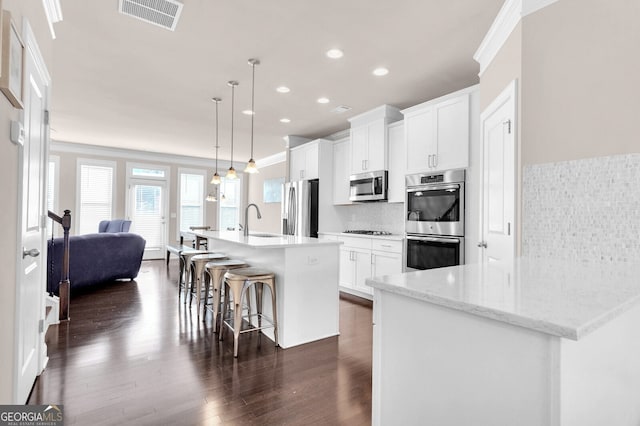 5910 Terrace Bend Way, Peachtree Corners, GA 30092 - kitchen featuring stainless steel appliances, a center island with sink, a kitchen breakfast bar, backsplash, and recessed lighting