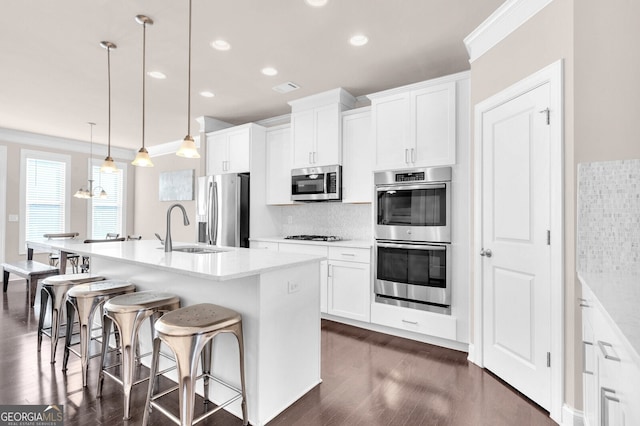 5910 Terrace Bend Way, Peachtree Corners, GA 30092 - kitchen featuring appliances with stainless steel finishes, dark wood-style floors, tasteful backsplash, a kitchen island with sink, and recessed lighting