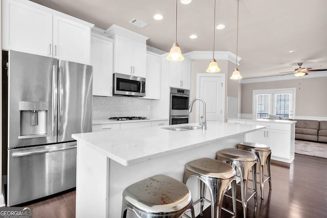 5910 Terrace Bend Way, Peachtree Corners, GA 30092 - kitchen with stainless steel appliances, dark wood finished floors, an island with sink, crown molding, and white cabinets