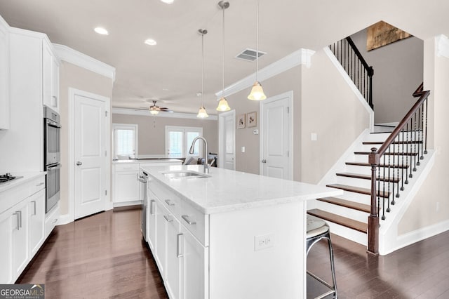 5910 Terrace Bend Way, Peachtree Corners, GA 30092 - kitchen with ornamental molding, dark wood-type flooring, appliances with stainless steel finishes, a center island with sink, and a ceiling fan