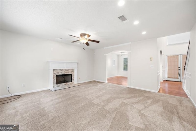1486 Rogers Crossing Dr, Lithonia, GA 30058 - unfurnished living room featuring carpet floors, ceiling fan, recessed lighting, a fireplace with raised hearth, and arched walkways
