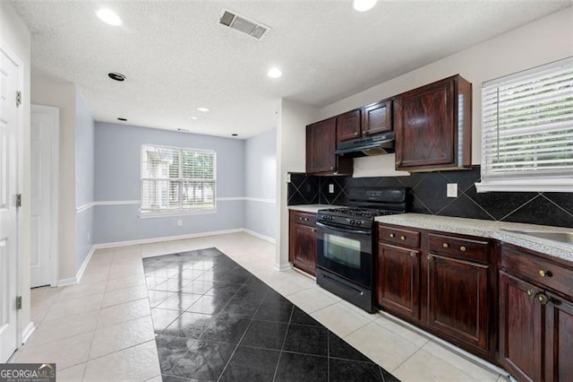 1486 Rogers Crossing Dr, Lithonia, GA 30058 - kitchen featuring black gas range, under cabinet range hood, recessed lighting, light countertops, and backsplash
