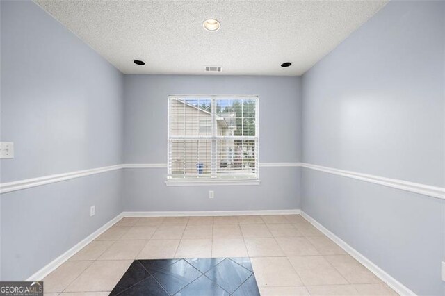 1486 Rogers Crossing Dr, Lithonia, GA 30058 - tiled spare room featuring a textured ceiling