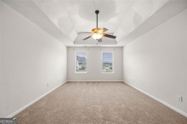1486 Rogers Crossing Dr, Lithonia, GA 30058 - unfurnished room with a ceiling fan, light carpet, a tray ceiling, and a textured ceiling