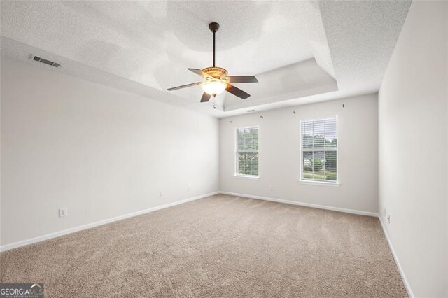 1486 Rogers Crossing Dr, Lithonia, GA 30058 - empty room featuring light carpet, ceiling fan, a tray ceiling, and a textured ceiling