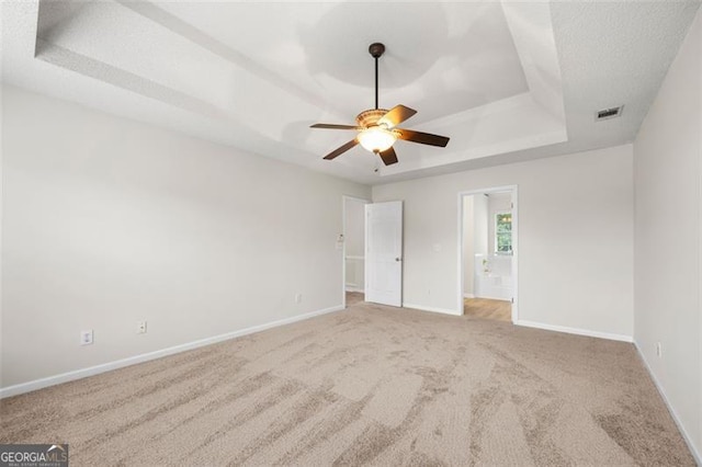 1486 Rogers Crossing Dr, Lithonia, GA 30058 - unfurnished bedroom with a raised ceiling, carpet floors, connected bathroom, and a ceiling fan