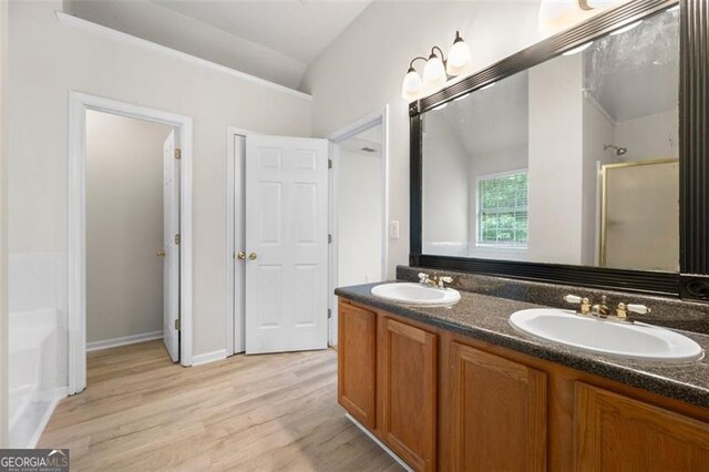 1486 Rogers Crossing Dr, Lithonia, GA 30058 - bathroom featuring double vanity, wood finished floors, a bath, and a shower with door