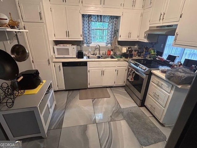 4514 Tifton Ct, Powder Springs, GA 30127 - kitchen featuring appliances with stainless steel finishes, under cabinet range hood, a sink, white cabinets, and light marble finish floors