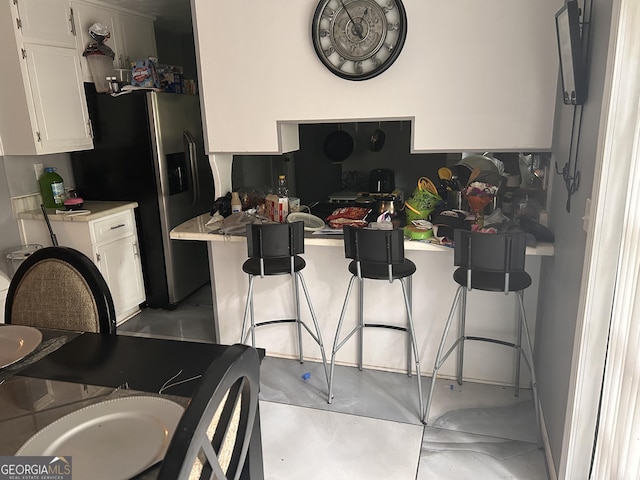 4514 Tifton Ct, Powder Springs, GA 30127 - kitchen featuring white cabinets, stainless steel refrigerator with ice dispenser, light countertops, and a kitchen breakfast bar
