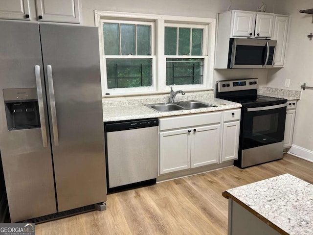 1829 Mercer Ave, College Park, GA 30337 - kitchen featuring appliances with stainless steel finishes, a sink, light wood finished floors, light countertops, and white cabinets