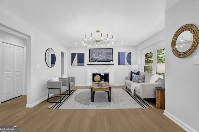 696 Kenilworth Cir, Stone Mountain, GA 30083 - living room with wood finished floors, baseboards, a chandelier, and a brick fireplace
