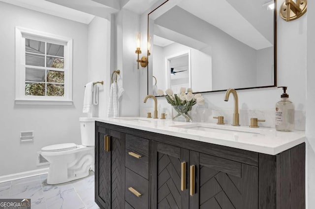 696 Kenilworth Cir, Stone Mountain, GA 30083 - full bathroom with marble look tile flooring, double vanity, baseboards, and toilet