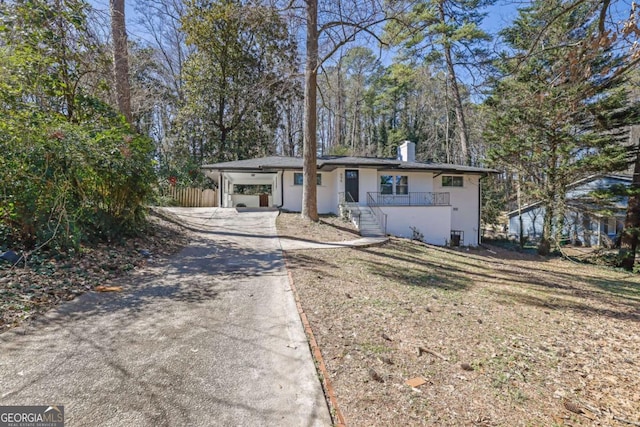 696 Kenilworth Cir, Stone Mountain, GA 30083 - view of front of property with driveway, a carport, a chimney, and stucco siding