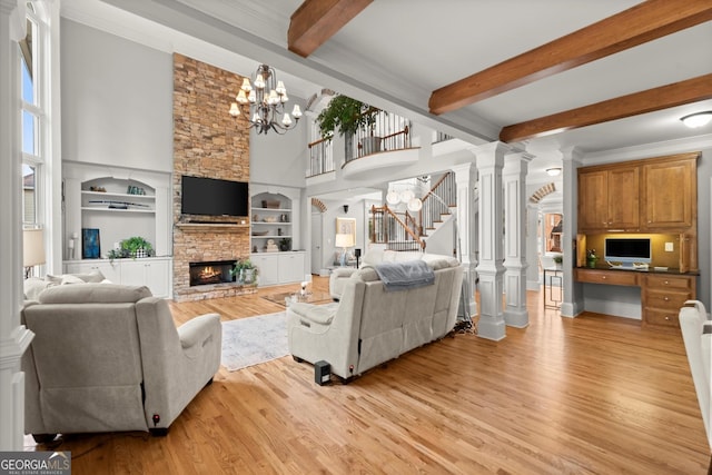 979 Pathview Ct, Dacula, GA 30019 - living area featuring stairway, light wood finished floors, a stone fireplace, a chandelier, and beam ceiling