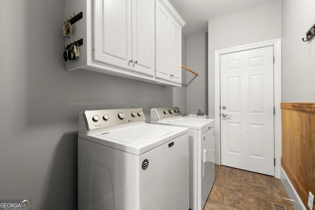 979 Pathview Ct, Dacula, GA 30019 - laundry area featuring independent washer and dryer, cabinet space, and stone finish flooring
